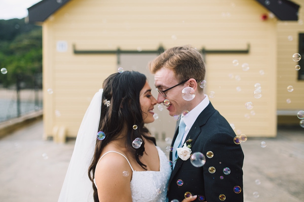 Bride and Groom blowing bubbles on Chowder Bay Wharf near Ripples Chowder Bay